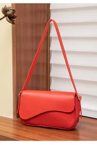 Dettaglio borsa a tracolla rossa in ecopelle con patta ondulata e fibbie dorate