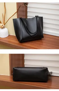 Détails de la base large et de la texture en similicuir noir lisse du sac fourre-tout