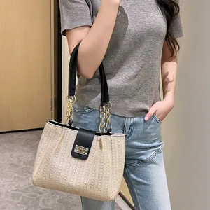 Minimalist beige woven tote bag with contrast black strap and gold twist lock clasp