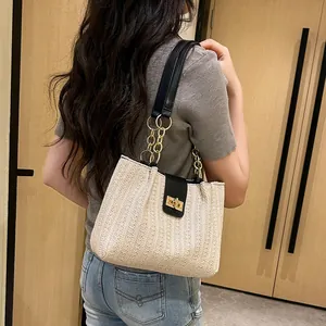 Chic woven beige tote bag with black leather straps and gold twist-lock buckle closure