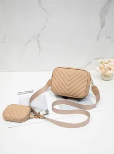 Détail du sac photo beige à surpiqûres en V avec mini pochette et bandoulière large