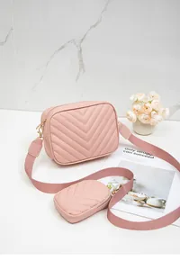 Détail du sac caméra matelassé rose clair avec broderie en V et bandoulière large