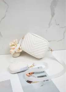 Détail d'un sac caméra blanc matelassé en V avec bandoulière large et pochette