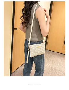 Mannequin portant un sac bandoulière tissé crème avec texture en V et détails dorés