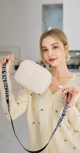 Detailansicht der cremefarbenen Stepptasche mit V-Muster-Stickerei und breitem Schultergurt