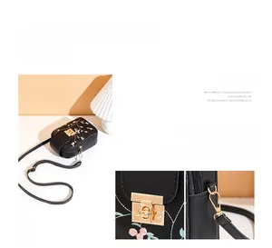 Detail view of pink floral embroidery and golden metal twist lock on black PU phone bag