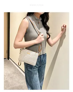 Détail du sac bandoulière tissé avec boucle dorée et bandoulière en cuir marron