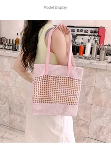 Close-up of pink hollow-out straw tote bag showing intricate woven mesh detail