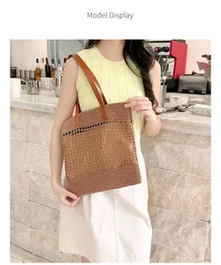 Close-up of brown woven tote bag with hollow out design and leather straps in a cafe setting