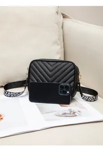 Close-up of black quilted crossbody bag with wide printed strap and phone size reference
