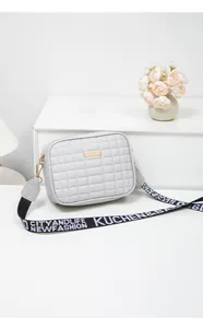 Close-up of light grey quilted PU leather crossbody bag with branded wide shoulder strap