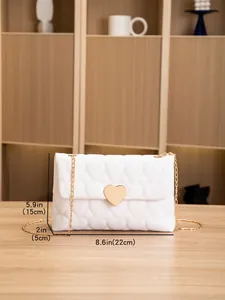 White quilted shoulder bag with heart lock detail and size dimensions on wood table