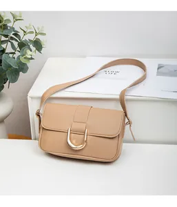 Detail of beige leather bag featuring textured lychee grain and gold horseshoe buckle