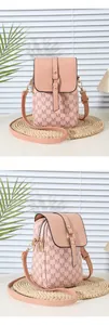 Detailed close-up of pink crossbody bag with M letter prints and double zippers