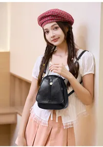 Mini sac à dos noir en cuir souple avec fermeture éclair porté par un mannequin
