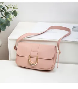 Detailed view of pink PU leather bag featuring a golden U-shaped buckle on a white stand