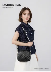 Detailed view of quilted black leather camera bag with a wide LOVE canvas strap