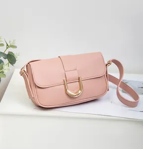 Detailed view of pink faux leather bag showing soft lychee texture and golden D-ring buckle