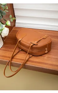 Detail der braunen Lederhandtasche mit Litschi-Muster, Gold-Reißverschluss und Logo