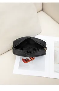 Interior view of the minimalist black embroidered crossbody bag with gold hardware