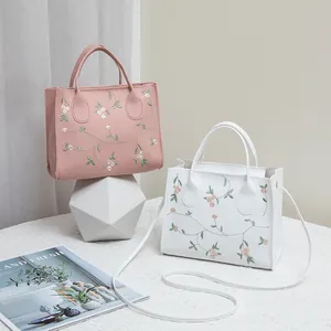 Elegant floral embroidery handbag with leather crossbody strap for women in pink and white