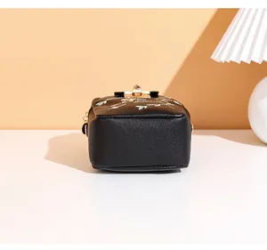 Detailed base of black crossbody bag featuring floral embroidery and gold metal clasp