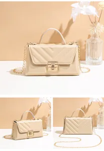 Close-up of beige V-quilted faux leather bag with gold chain strap and square metal lock