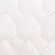 Macro shot of white leather with quilted heart patterns and precise stitching detail