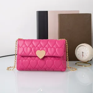 Detail shot of the gold heart-shaped metal twist lock on a magenta quilted shoulder bag