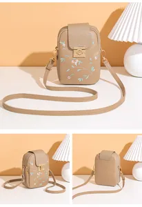 Detailed view of khaki floral embroidered phone bag with gold clasp and strap