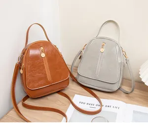 Détails de sacs à bandoulière en similicuir texturé marron et gris sur une surface en bois