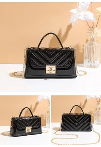 Detailed view of black patent leather crossbody bag with V-quilted pattern and gold lock