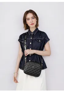 Close-up of quilted crossbody bag with golden hardware and LOVE embroidered strap