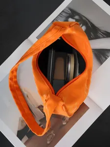 Detail der orangefarbenen Handtasche mit großem Innenraum für Make-up-Produkte