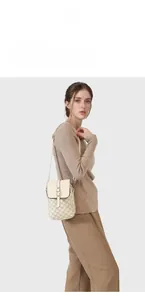 Vertical off-white crossbody bag with brown M-letter pattern on a model side view