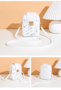 Detail of white PU leather phone bag with pink floral embroidery and golden metal lock