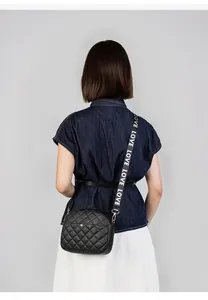 Close-up of black quilted camera bag with sporty LOVE lettered fabric strap detail