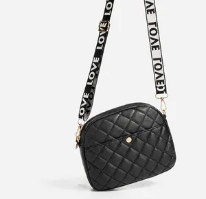 Details der schwarzen Stepptasche mit goldener Hardware und zwei Wechselriemen