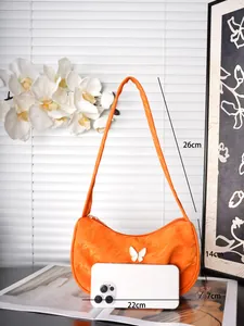 Detailansicht der orangefarbenen Satin-Umhängetasche mit Maßen 22x14x7cm und Schleife