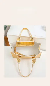 Detailansicht der mehrschichtigen Innenfächer in einer goldenen geprägten Handtasche