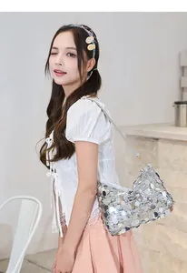 Close-up of sparkling silver sequins and delicate shoulder strap on a sleek handbag