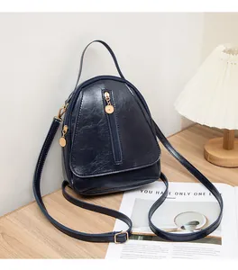 Détail du mini sac en cuir PU bleu marine avec fermeture éclair dorée sur table