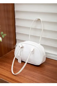 Detailansicht der weißen Ledertextur mit Lychee-Muster auf der Schultertasche