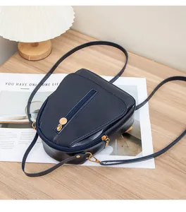 Détail du mini sac à dos bleu foncé avec fermeture éclair dorée sur simili cuir poli