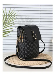 Detailed view of the double zipper compartments and gold hardware on this crossbody bag