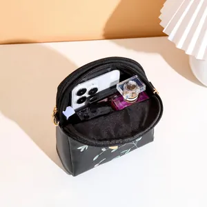 Mini floral embroidery crossbody bag with gold zipper showing daily essentials inside