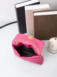 Detail view of pink quilted heart handbag with gold chain strap and heart-shaped lock