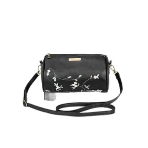 Sac cylindre noir brodé de fleurs avec fermeture dorée et bandoulière en cuir