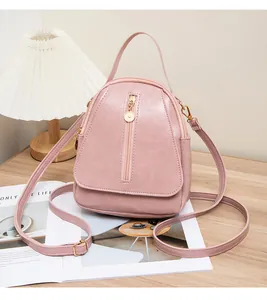 Mini sac à dos en cuir souple rose posé sur une table avec décor de vie