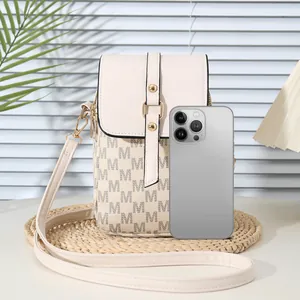 Beige monogram crossbody phone bag with gold hardware on a woven mat display